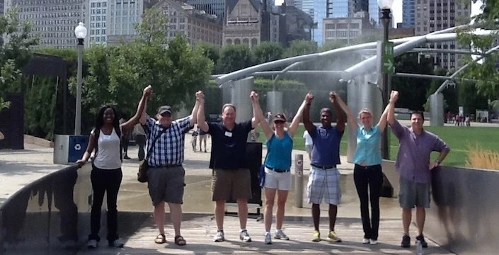A group of people posing for a picture in front of a fountain.