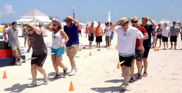 A group of people on a beach with cones in front of them.