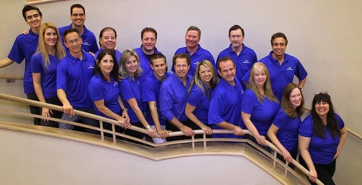 A group of people in blue shirts posing for a photo.