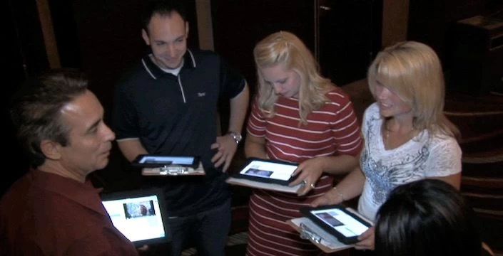 A group of people looking at a tablet computer.