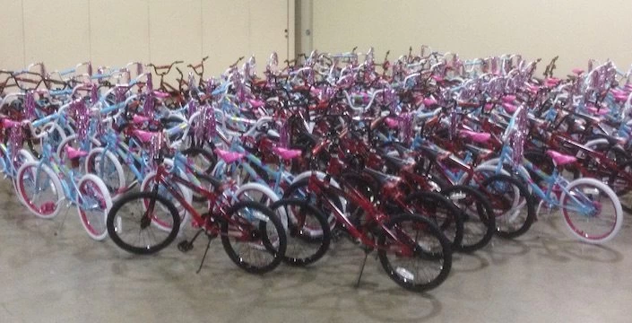 Many bicycles are lined up in a large room.
