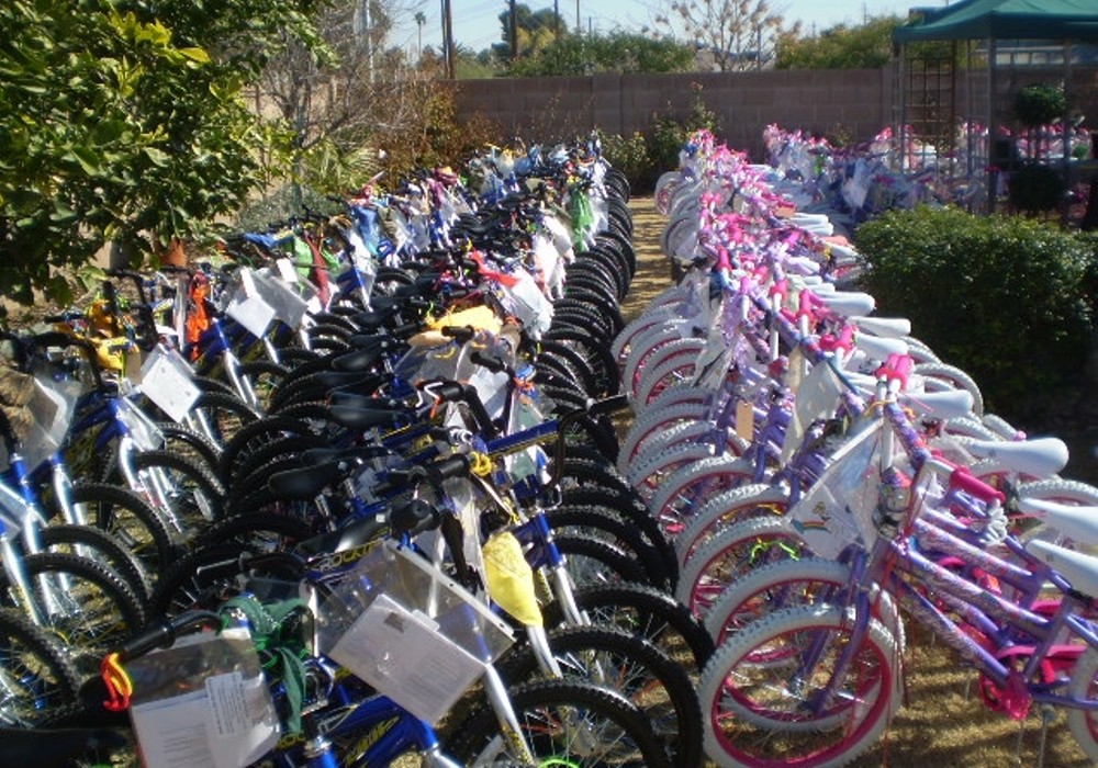Many bicycles are lined up in a yard.