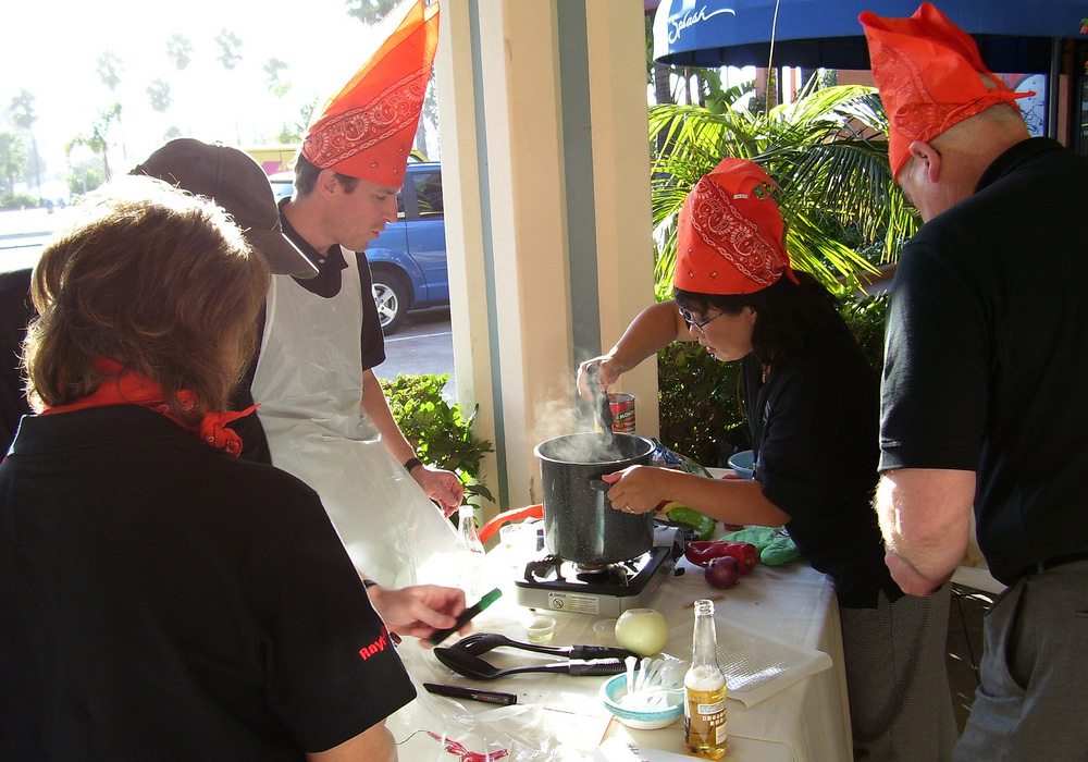 A group of people in black hats preparing food.