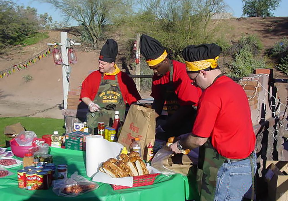 A group of men preparing food at a table.