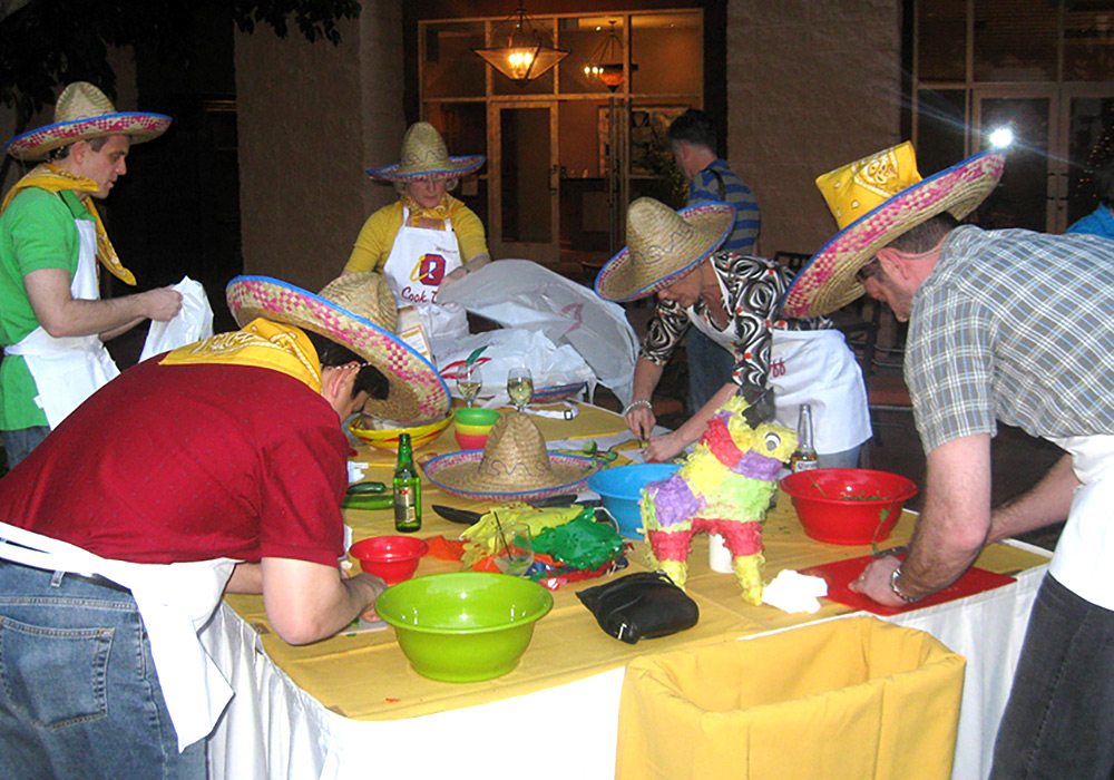 A group of people preparing food at a table.