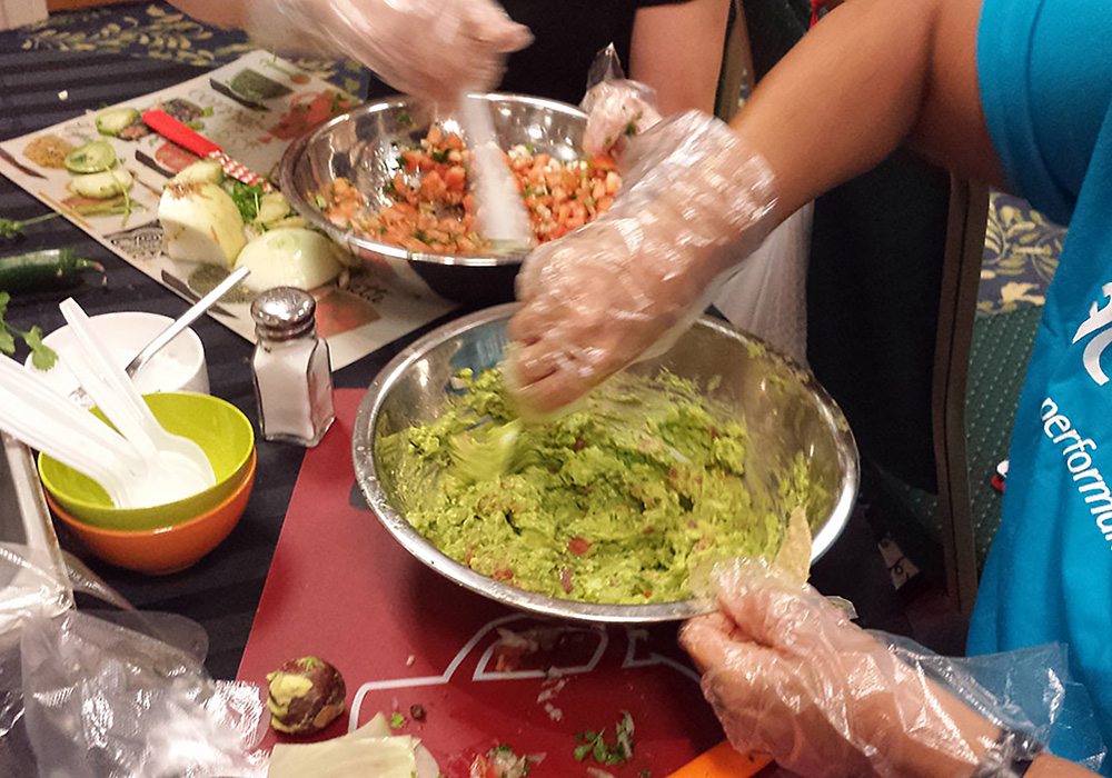 A group of people preparing guacamole.