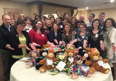 A group of people posing for a picture with teddy bears.