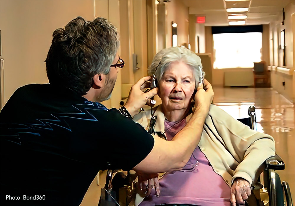 A woman in a wheelchair is being listened to by a doctor.