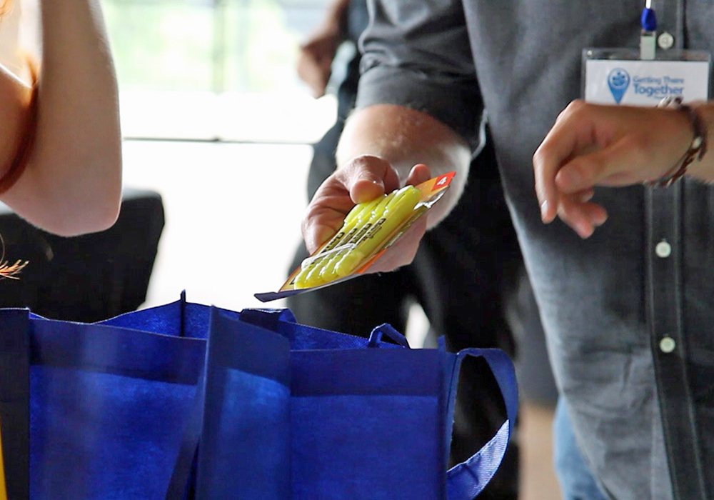 A woman is holding a blue shopping bag.