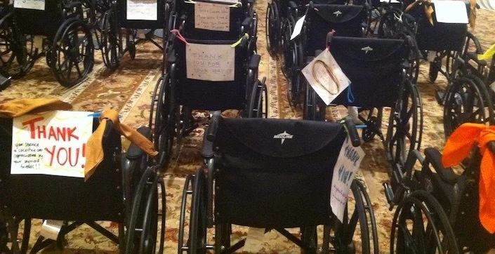 A room full of wheelchairs lined up with thank you notes.