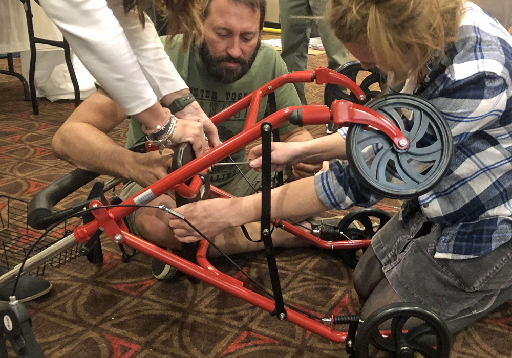 A group of people working on a walker.