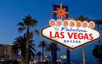 The las vegas sign is lit up at night.