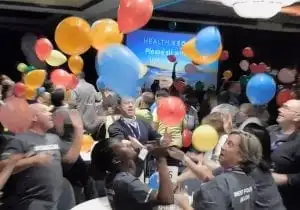 Best corporate events: A group of people are enthusiastically throwing balloons in the air.