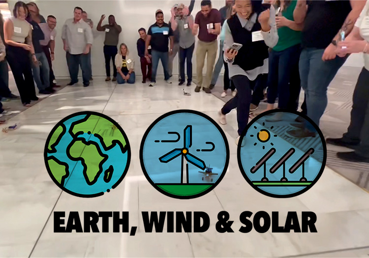 A group of people standing in a room with the words earth wind and solar.
